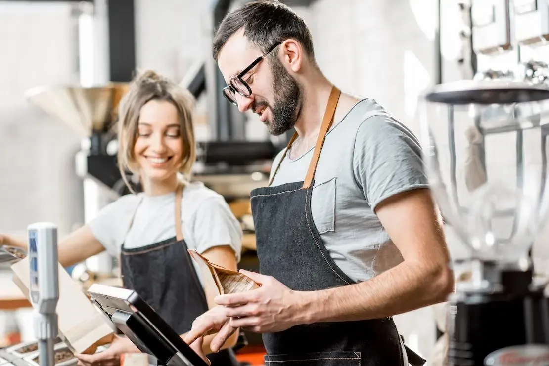 Mitarbeitende bedienen die Kasse in einer Bäckerei