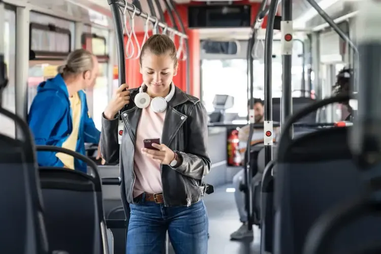 Junge Frau mit Smartphone im Bus